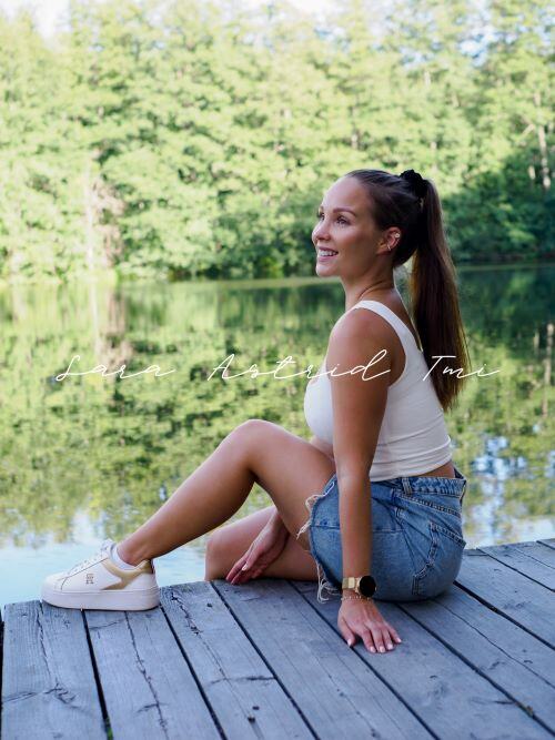 Nainen istuu laiturilla kuvapankkikuva